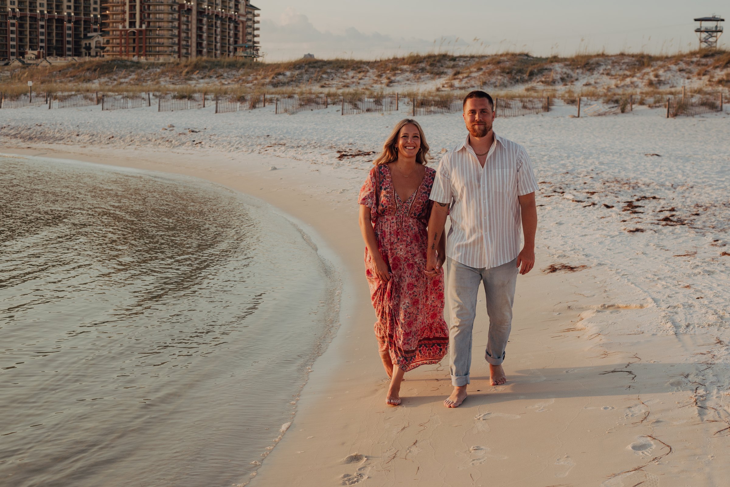 Liz and her husband walking the shoreline at sunset